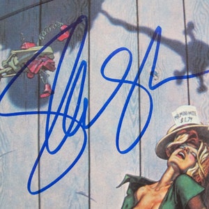 May include: A blue signature on a white background. The signature is for "Jeff Beck".