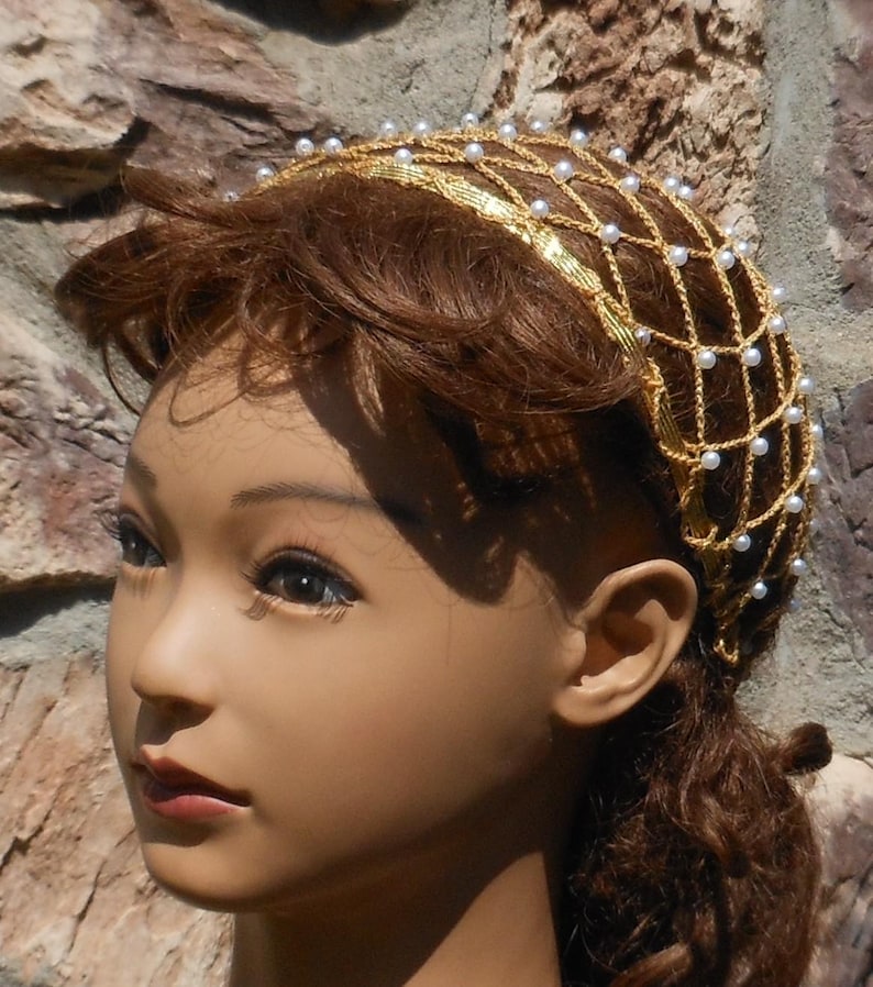 Op de afbeelding: Een gouden en witte kralen haar kroon met een net ontwerp. De kroon wordt gedragen door een mannequin met bruin haar.