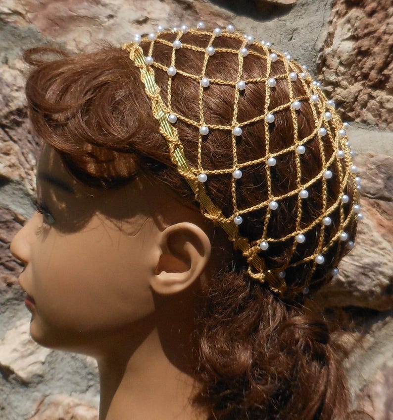 Op de afbeelding: Een gouden gehaakt haarnet met witte parel kralen. Het net wordt gedragen door een mannequin met bruin haar.