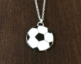May include: A silver chain necklace with a black and white soccer ball pendant.