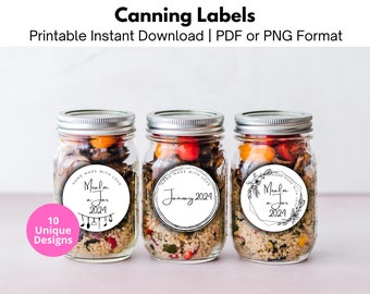 Könnte beinhalten: Drei Glasgläser mit silbernen Deckeln, gefüllt mit verschiedenen Zutaten. Jedes Glas hat ein rundes, weißes Etikett mit schwarzem Text, der "Hand Made With Love" und "Meal in a Jar 2024" lautet. Die Etiketten haben unterschiedliche Designs, darunter Noten, einen Blumengirlanden und einen einfachen Kreis.