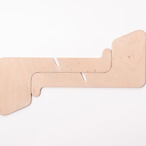 May include: A light brown wooden stand with two interlocking pieces. The stand is designed to hold a laptop or tablet.