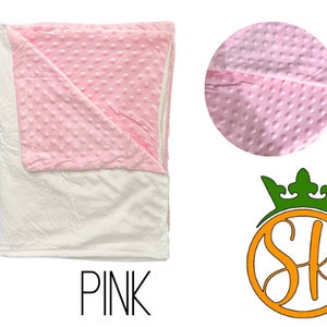 May include: Pink and white weighted blanket with a soft, textured surface. The blanket is folded in half and has a white backing.