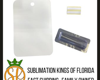 Puede incluir: Un espacio en blanco de sublimación rectangular transparente con una parte superior redondeada y un agujero. También se incluye una placa de identificación magnética y una pequeña tira adhesiva. El texto "SUBLIMATION KINGS OF FLORIDA" es visible.