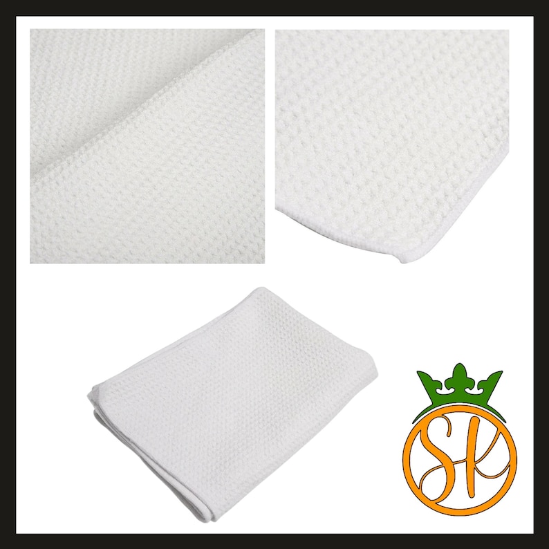 Puede incluir: Pa&ntilde;o de limpieza de microfibra blanco con tejido de gofre. La imagen muestra detalles de primer plano de la textura de la tela, junto con un pa&ntilde;o doblado. El pa&ntilde;o es de color blanco brillante y parece nuevo.