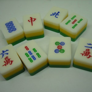 May include: A set of nine Chinese mahjong tiles with various symbols and numbers. The tiles are white with green, yellow, and red accents. The symbols include circles, dots, and Chinese characters.