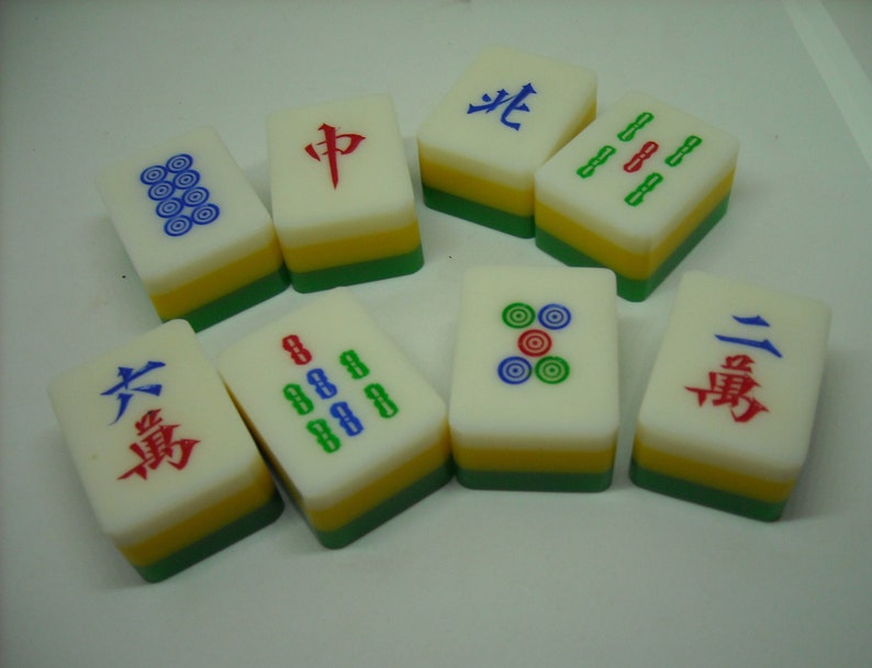 May include: A set of nine Chinese mahjong tiles with various symbols and numbers. The tiles are white with green, yellow, and red accents. The symbols include circles, dots, and Chinese characters.