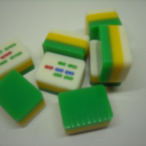 May include: A set of six green, yellow, and white mahjong tiles. The tiles have Chinese characters and symbols on them.