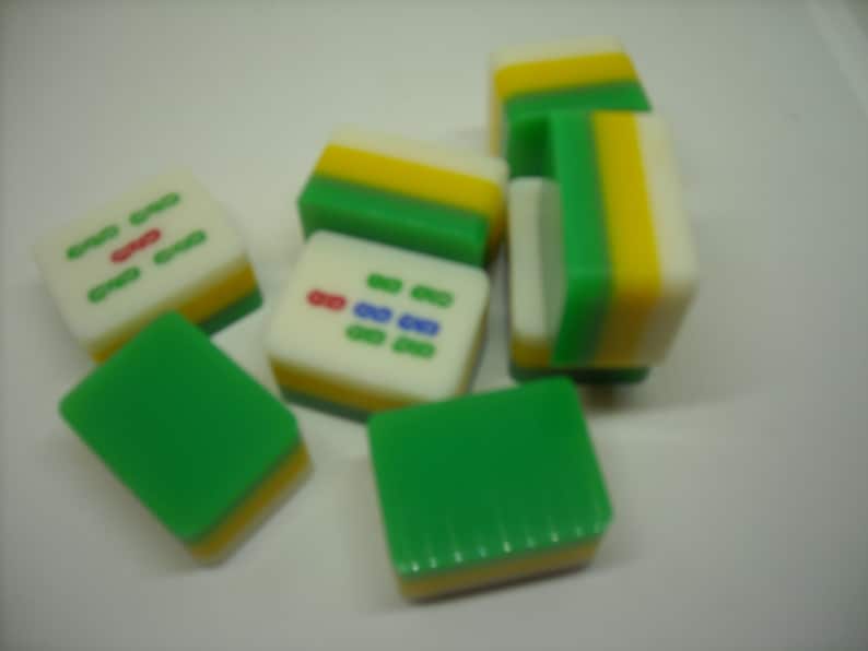 May include: A set of six green, yellow, and white mahjong tiles. The tiles have Chinese characters and symbols on them.