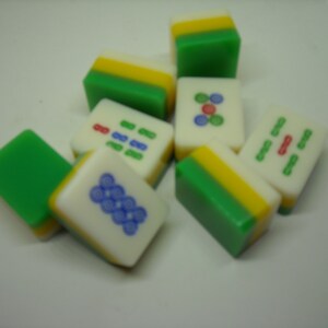May include: A set of nine green, yellow, and white mahjong tiles with various Chinese characters and symbols.