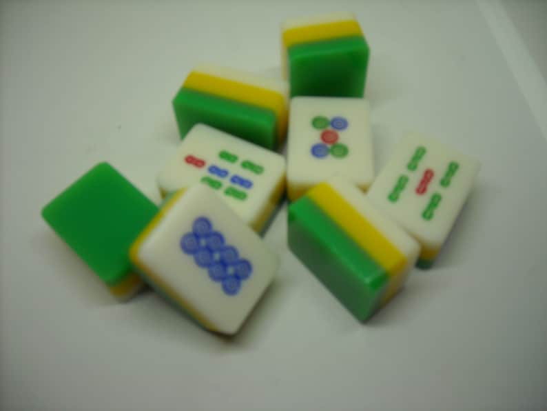 May include: A set of nine green, yellow, and white mahjong tiles with various Chinese characters and symbols.