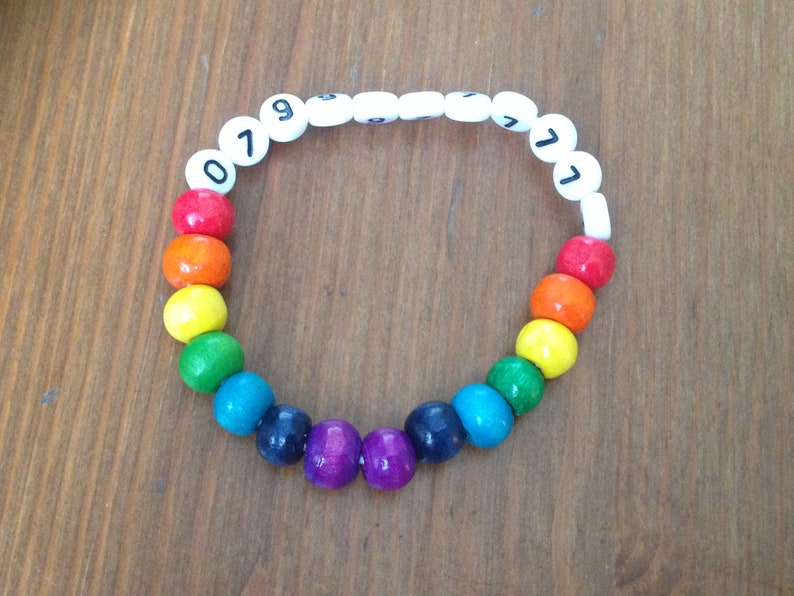 Peut inclure: Un bracelet de perles de couleur arc-en-ciel avec des perles blanches sur lesquelles sont imprim&eacute;s les chiffres 079771.