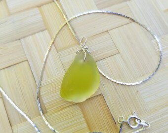 Pendant of striking yellow green seaglass wrapped in sterling silver wire and hung on sterling silver chain