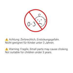 May include: A red circle with a diagonal line through it. The circle has a white background and the text "0-3" inside. A black and white illustration of a baby's face is inside the circle. The text "Achtung: Zerbrechlich, Erstickungsgefahr. Nicht geeignet f&uuml;r Kinder unter 3 Jahren." is below the circle. The text "Warning: Fragile, Small parts may cause choking. Not suitable for children under 3 years." is below the German text.