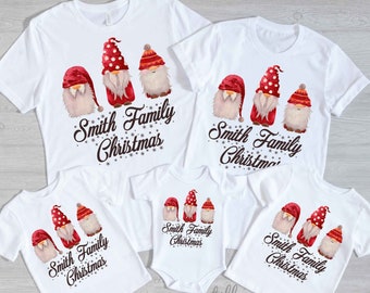 Peut inclure: Quatre t-shirts blancs avec un motif de gnome de Noël. Les t-shirts portent l'inscription "Smith Family Christmas".