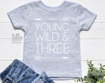 May include: A gray short-sleeved t-shirt with the text "Young Wild & Three" in white, with arrows on either side of the text.