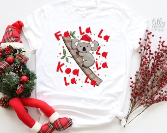 May include: White t-shirt with a red and green Christmas design featuring a koala wearing a Santa hat and the words "Fa La La Koa La La La"