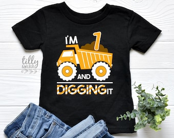 May include: Black t-shirt with a yellow dumper truck graphic and the text "I'm 1 and digging it".