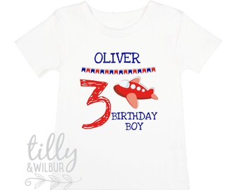 May include: White t-shirt with a red airplane and the number 3, with the text "Oliver" and "Birthday Boy" in blue.