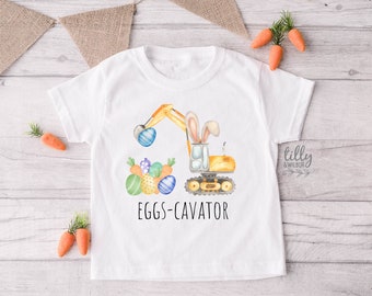 May include: A white t-shirt with a yellow excavator holding Easter eggs. The excavator has bunny ears and the text "EGGS-CAVATOR" is printed below the image.