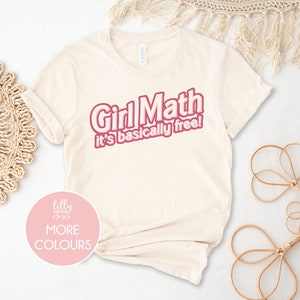 May include: A beige t-shirt with the text "Girl Math it's basically free!" in pink lettering.