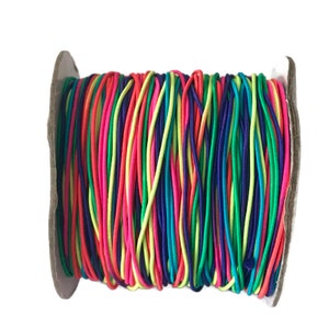 May include: A spool of colorful elastic string in shades of pink, green, blue, yellow, and red. The string is wound tightly around the spool.