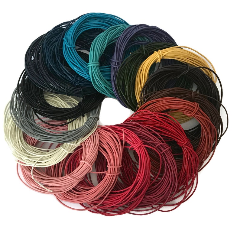 May include: A variety of colors of leather cord, wound into coils, arranged in a circle. The colors include red, pink, white, gray, black, brown, yellow, green, blue, and purple.