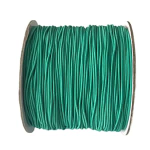 May include: A spool of teal green elastic cord. The cord is wound tightly around a cardboard spool.