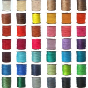 May include: A collection of 36 spools of waxed cord in various colours, including red, blue, green, yellow, and brown. The spools are arranged in a grid pattern on a white background.