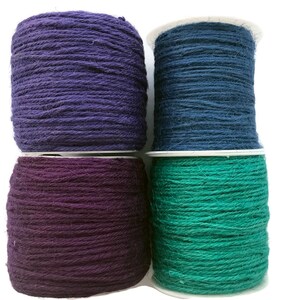 May include: Four spools of twine in different colors: purple, dark blue, dark purple, and teal.