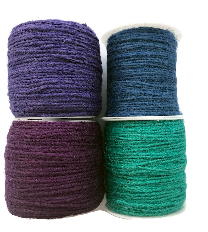 May include: Four spools of twine in different colors: purple, dark blue, dark purple, and teal.