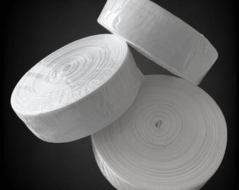 May include: Three rolls of white elastic fabric, each rolled up and wrapped in plastic.