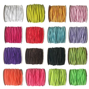 May include: Assortment of 16 spools of colourful elastic cord. The cords are wound around cardboard spools. The colours include white, yellow, orange, pink, red, light blue, purple, brown, black, orange, pink, green, and lime green.