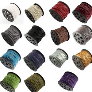 Peut inclure: Assortiment de bobines de cordon en cuir de différentes couleurs, notamment noir, marron, gris, bleu, vert, violet, rouge et blanc. Les bobines sont disposées en rangées sur un fond blanc.