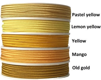 May include: Five spools of elastic cord in different shades of yellow, from pale yellow to gold. The spools are labeled "Pastel yellow", "Lemon yellow", "Yellow", "Mango", and "Old gold".