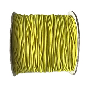 May include: A spool of bright yellow elastic cord, perfect for crafting projects.
