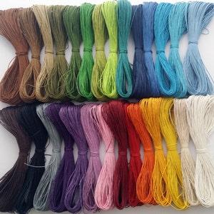 May include: Assortment of 24 spools of colourful waxed cotton cord. The cords are arranged in rows of 6, with each row featuring a different colour palette. The colours include brown, green, blue, purple, red, orange, yellow, and white.