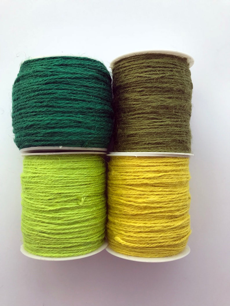 May include: Four spools of twine in green, olive green, lime green, and yellow. The spools are stacked in two rows of two.