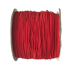 May include: A spool of red elastic cord, perfect for crafting projects.