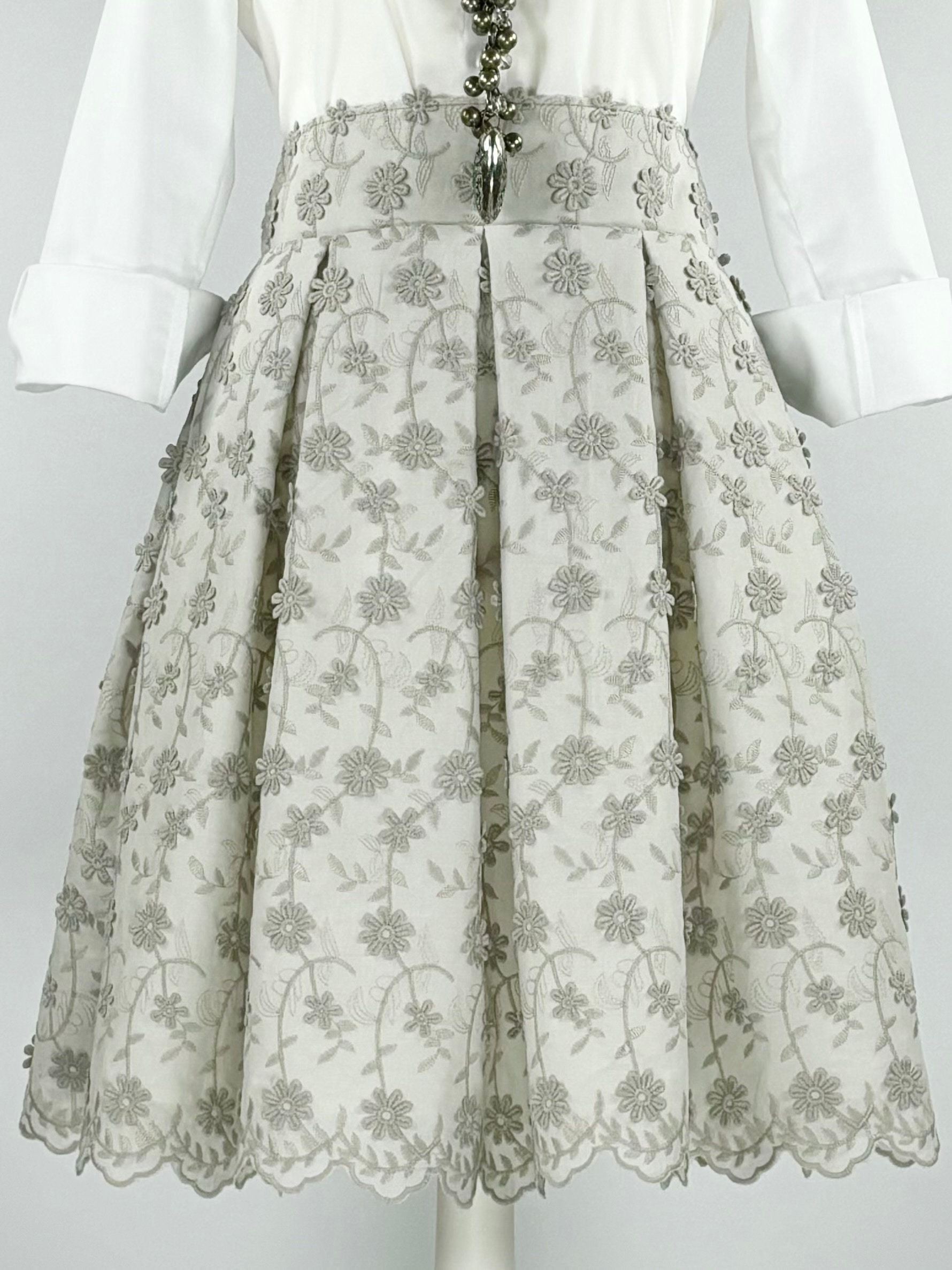 Knee-length pleated cotton skirt with floral embroidery and lace trim
