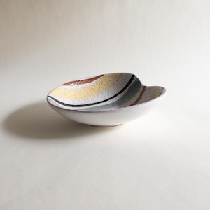 May include: A set of three ceramic mugs with a speckled, matte finish. Each mug features a different color: light blue, cream, and gray. The mugs have a simple, modern design, perfect for coffee or tea.