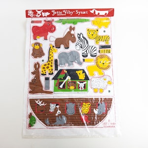 May include: A white paper sheet with a colourful illustration of Noah's Ark with animals. The ark is brown with a green roof. The animals include a giraffe, zebra, lion, elephant, kangaroo, monkey, tiger, sheep, hippopotamus, rhinoceros, deer, cat, dog, and a parrot. The text on the sheet reads "Jette Viby Sysart Denmark".