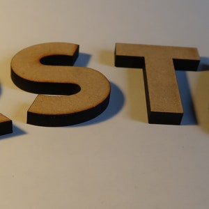 May include: Wooden letters spelling out the word "RSTU" in a light brown color with black edges.