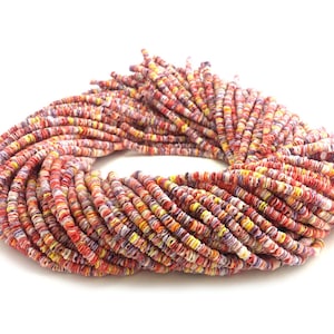 May include: A strand of colorful, round, flat, and textured beads. The beads are a mix of red, orange, yellow, white, and purple.