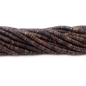 May include: A strand of brown coconut shell beads. The beads are round and have a natural, rustic look.
