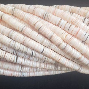 May include: A strand of white and pink shell beads. The beads are flat and round, with a slightly iridescent finish.