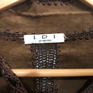 May include: Brown suede jacket with brown crocheted trim and a label that reads "IDI BY MATTHEW".