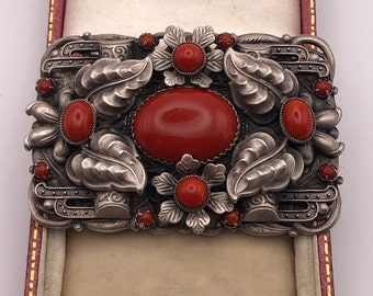 1920s Neiger Brothers Rare Brooch with a large central red cabochon glass stone surrounded by other cabochons and raised leaves and flowers