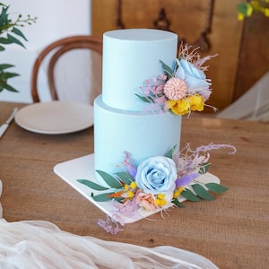 A set of two wedding cake toppers, blue floral cake decorations, green leaf cake topper flowers, rustic-style wedding.