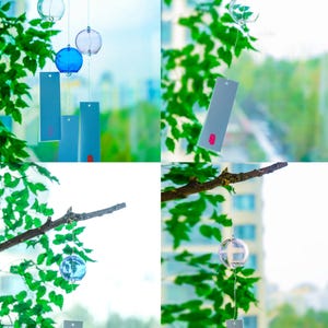 May include: A set of glass wind chimes featuring spherical clear and blue glass bells suspended by thin strings. Each bell is attached to a rectangular light blue paper strip with a small red rectangular accent at the bottom edge.